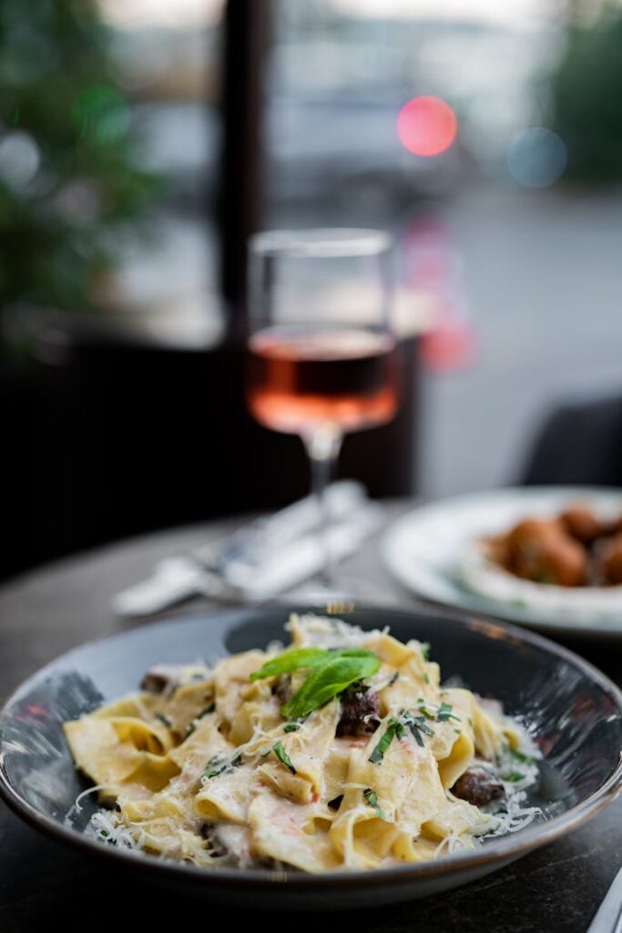 A plate of pasta with mushrooms and wine